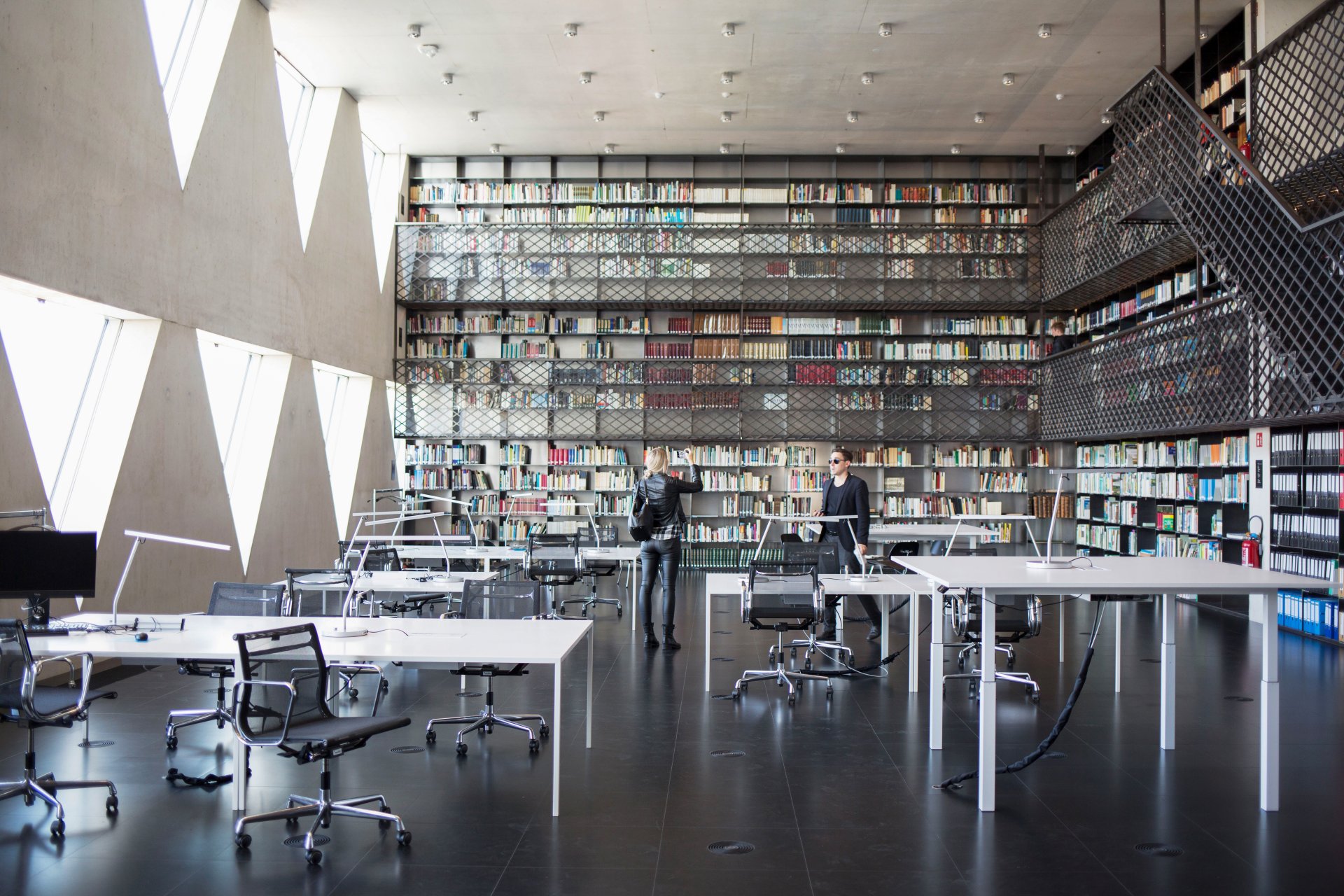 Interior of the Library of Provinciehuis Antwerp, a woman is taking a picture with her mobile